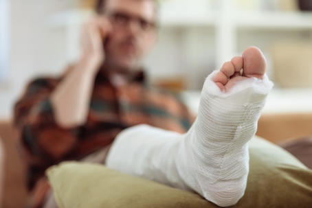 man with broken leg at home